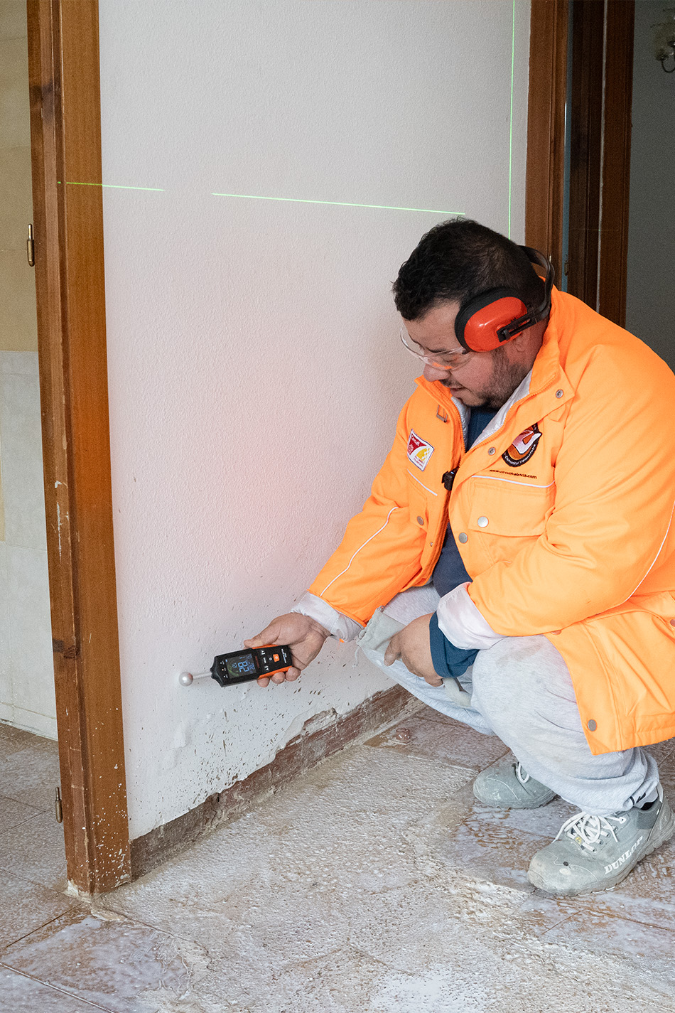 profesional tomando humedad de pared